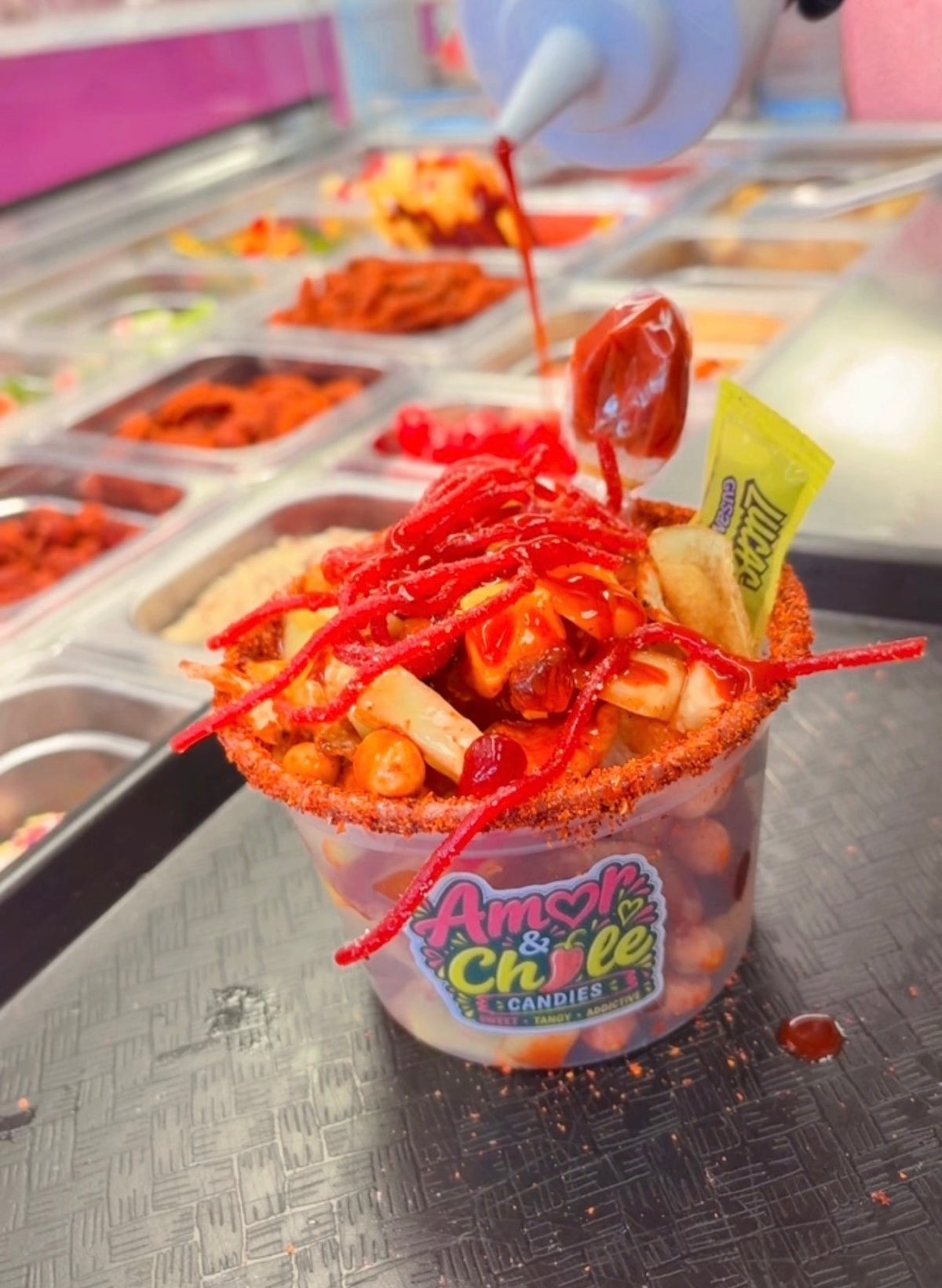 Load video: Customer building a custom chamoy Candy bowl at the Amor &amp; chile llena tu Loko bar inside La Gusguerita in Edmond, Oklahoma.